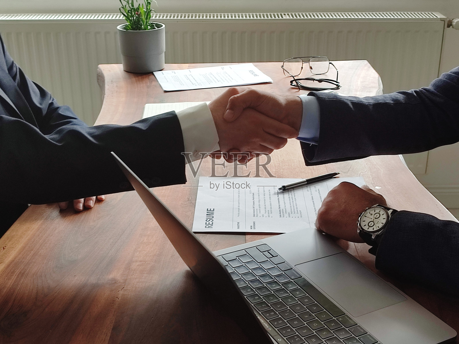 房产中介与客户握手庆祝完成购房保险和投资贷款合同后，握手并拍下成功成交的股票照片照片摄影图片