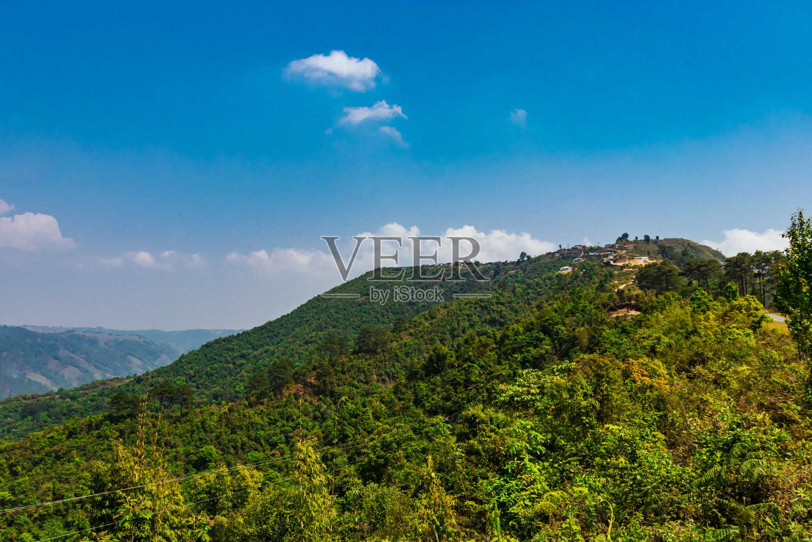 山覆盖着绿色的森林和明亮的蓝天在早上从平坦的角度照片摄影图片