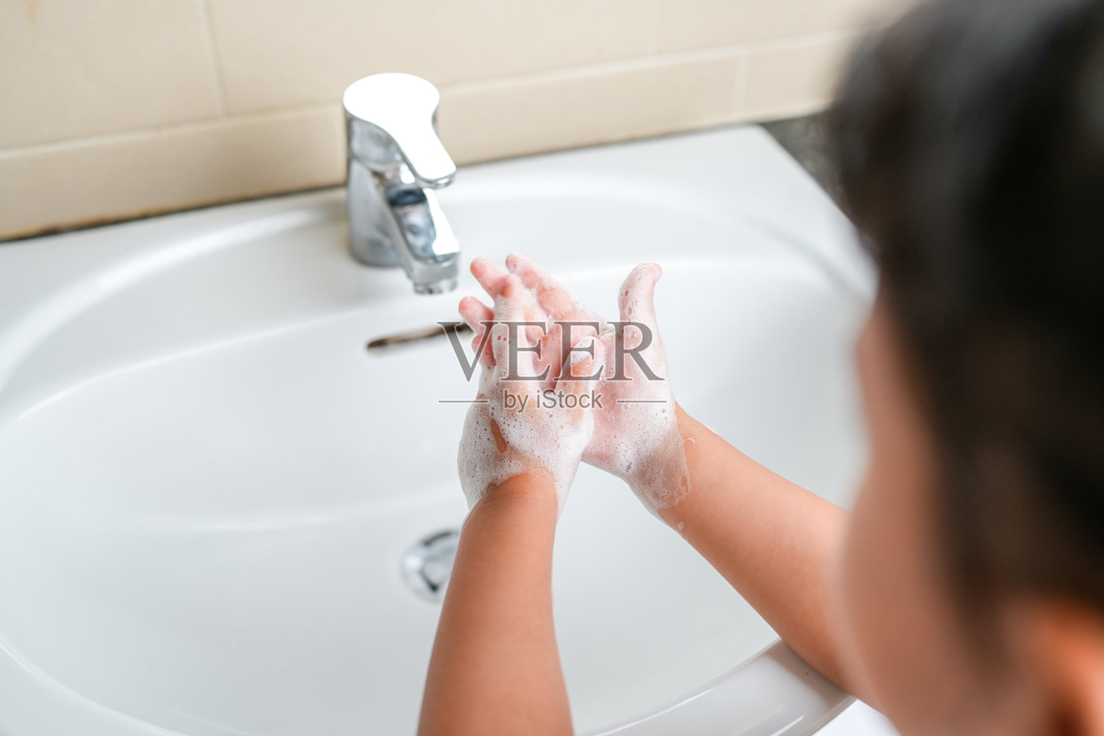 小女孩在水槽洗手，预防病毒、细菌和病菌照片摄影图片