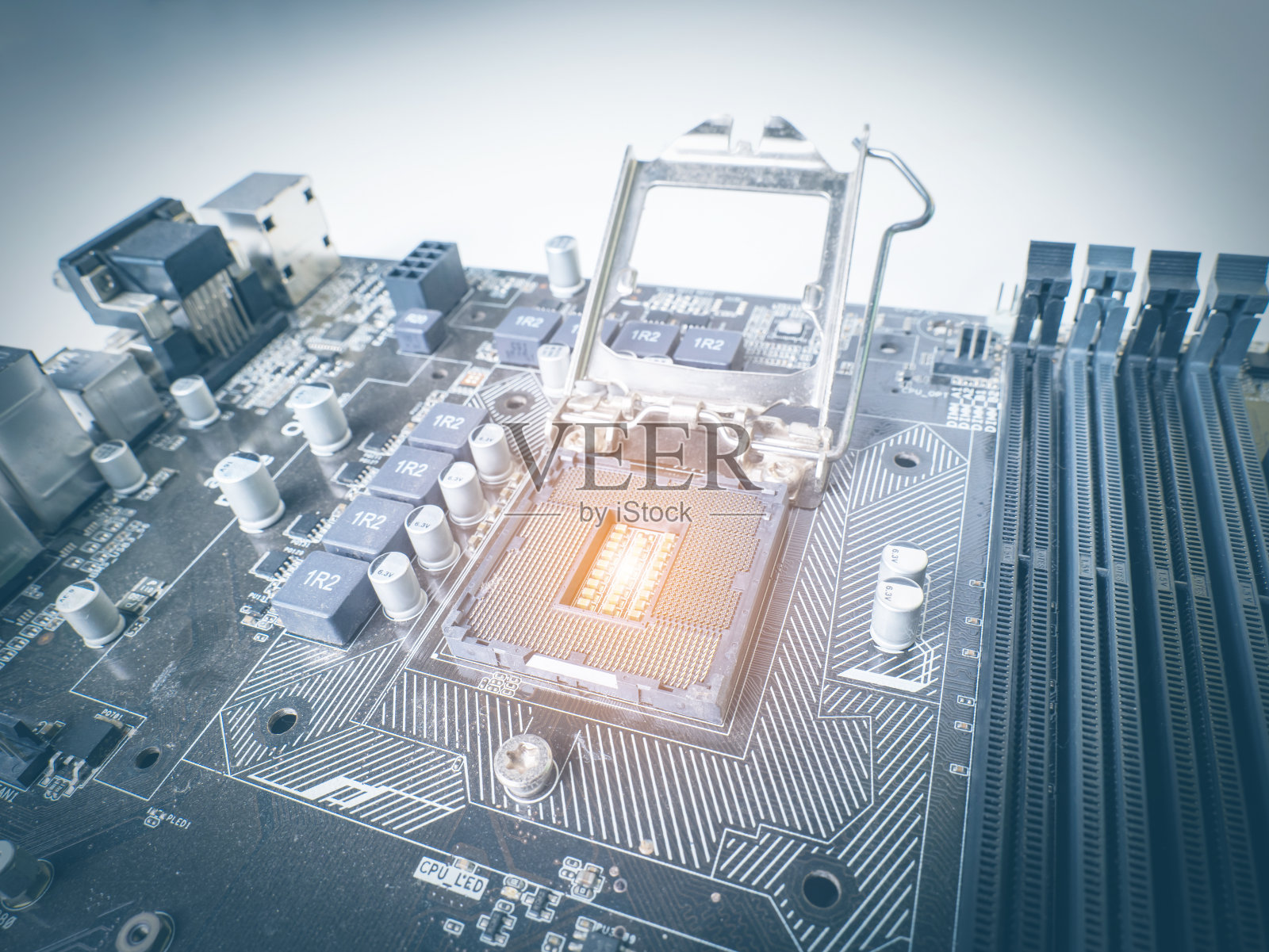 CPU主板插槽用于冷却，旧主板，灰尘很多，放橙色灯为暖色调，在CPU插槽，旁边有一个RAM插槽，有一个电容照片摄影图片