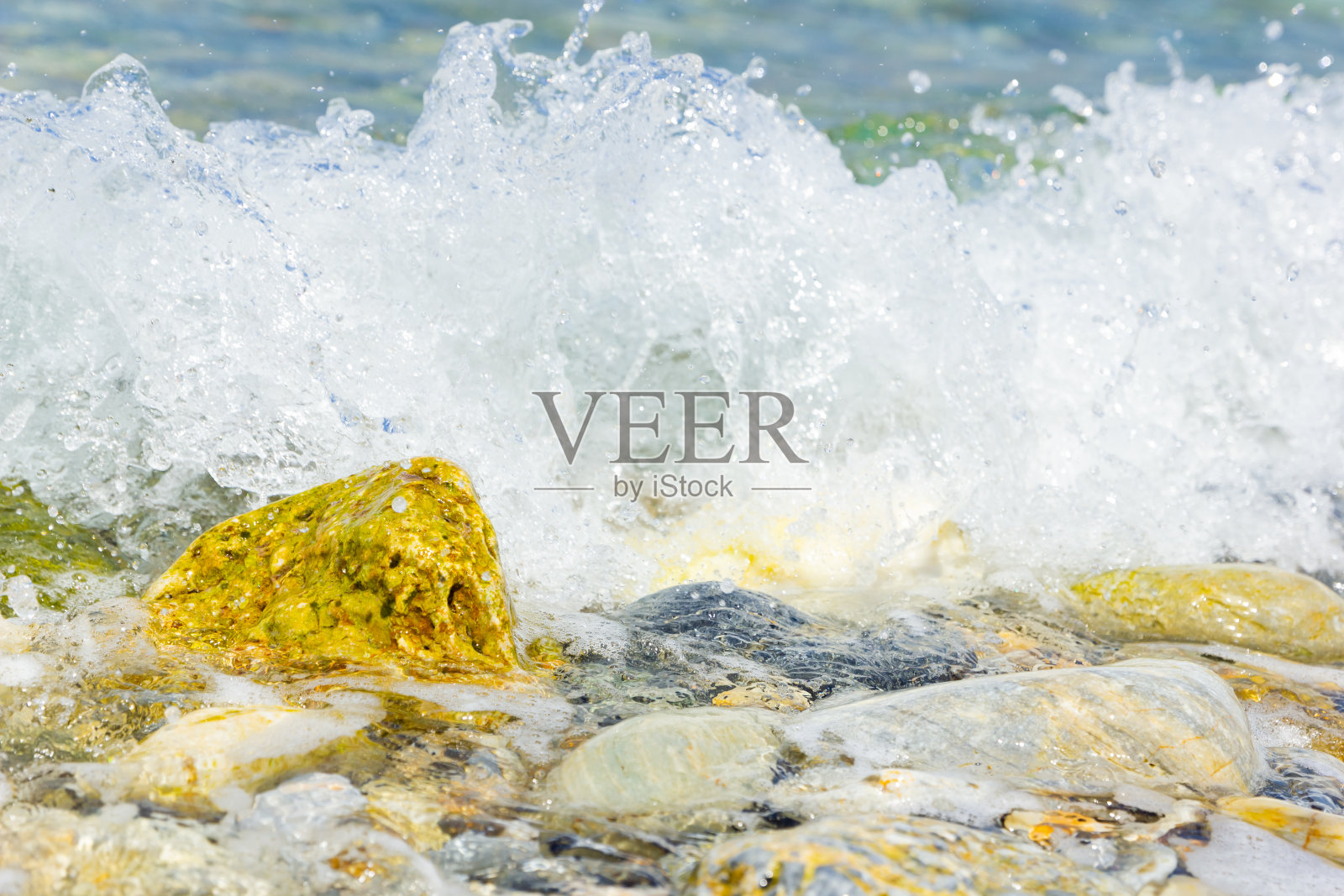 海浪和卵石。暑假的概念。带泡沫的海浪涌向海岸卵石。旅游的概念照片摄影图片