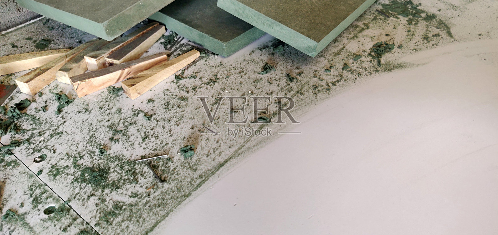 正在进行的工作-一个木匠的工作区，绿色的木板或木板杂乱地散落在工作台上或长凳上，有文本的复制空间照片摄影图片