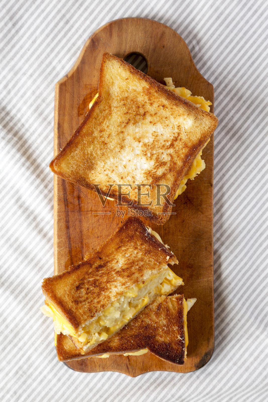 自制的烤通心粉和奶酪三明治放在质朴的木板上，从上面看。平躺，俯视图，头顶。照片摄影图片