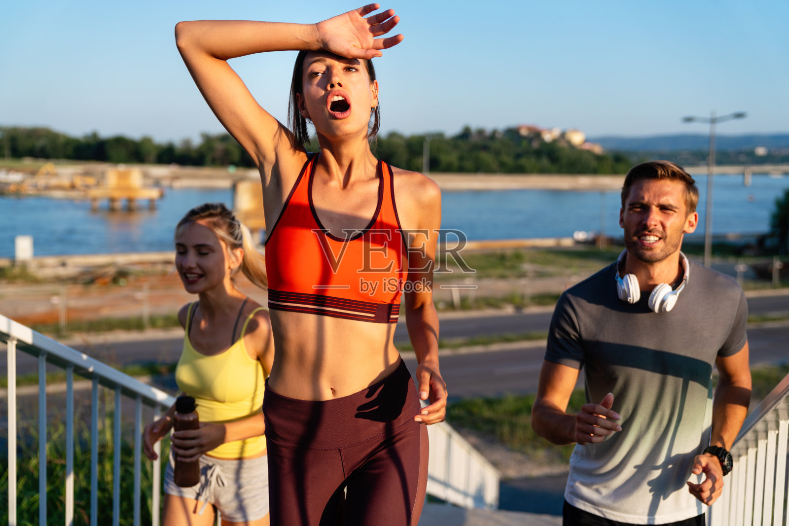 健身运动是人们跑步的生活方式观念。一群年轻人一起在户外慢跑。照片摄影图片