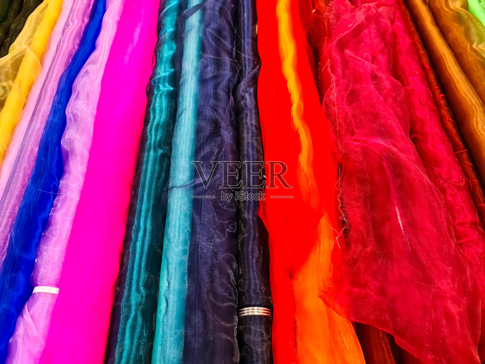 在布料市场上发现的不同颜色的布料和布料的样品。照片摄影图片