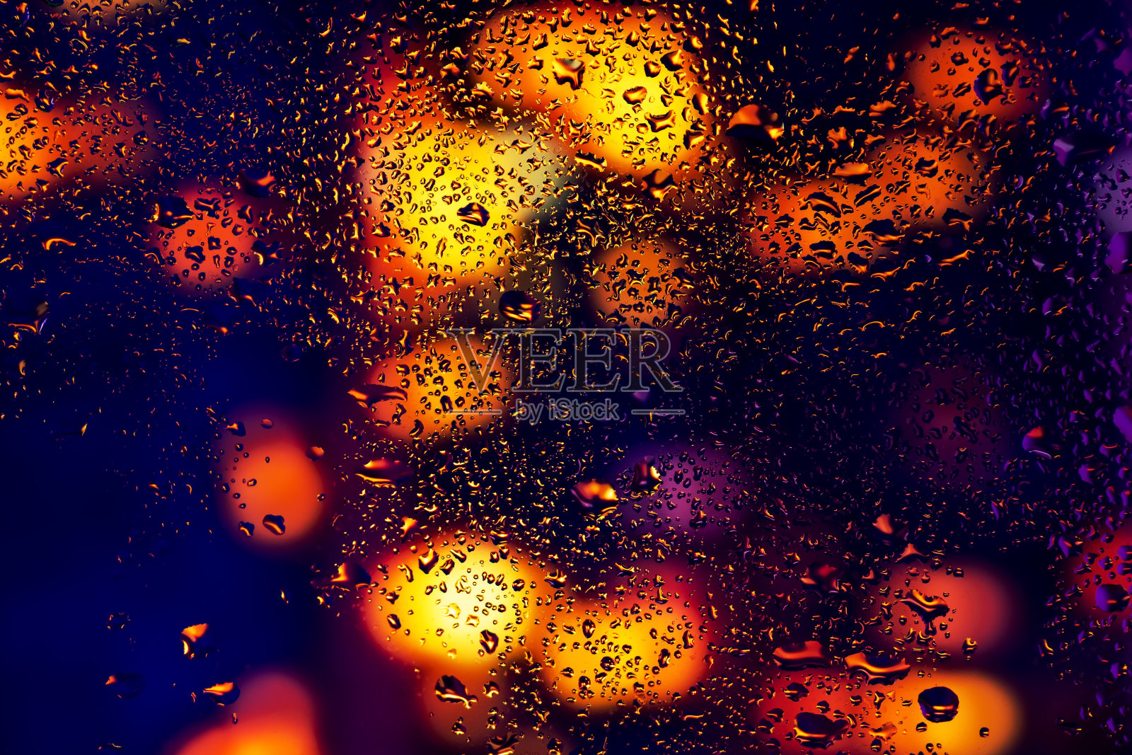 水珠凝结在窗玻璃上。抽象的背景夜灯照片摄影图片