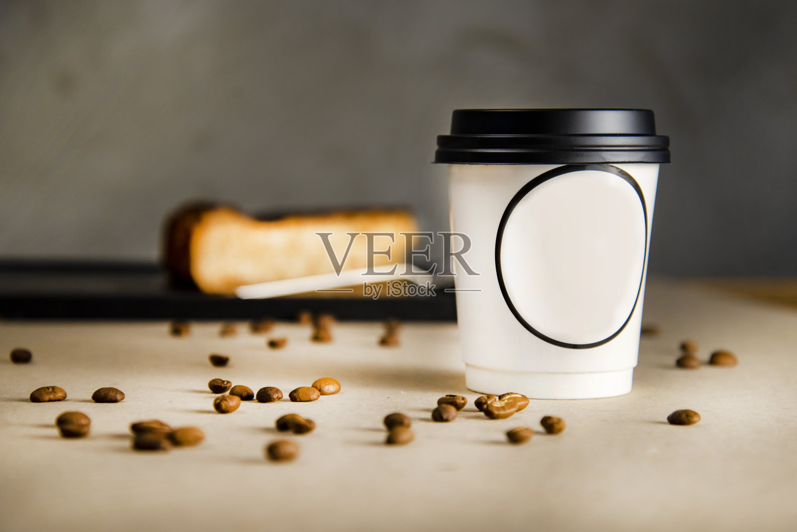 咖啡美式咖啡站在灰色背景前的黑布上。后面有芝士蛋糕照片摄影图片