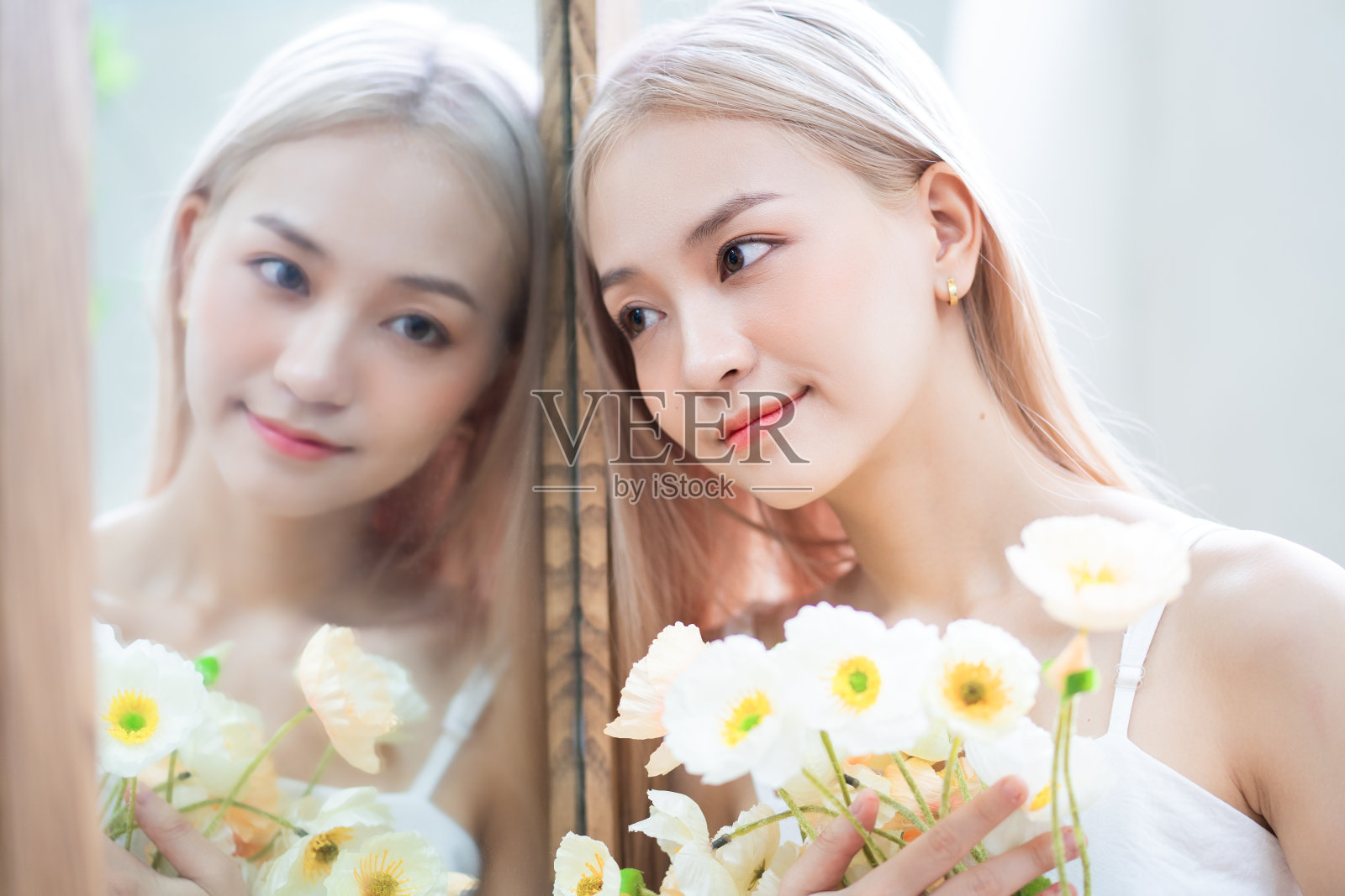 年轻亚洲女孩的肖像和她在镜子中的倒影照片摄影图片