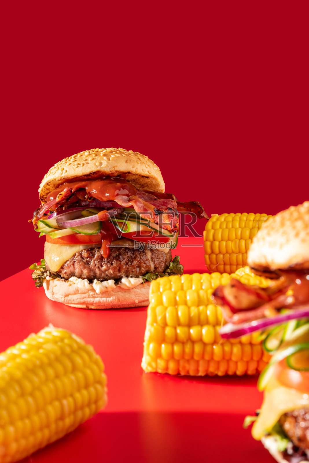 大胆的新鲜芝士汉堡，搭配生菜，黄瓜，番茄和培根，鲜红照片摄影图片