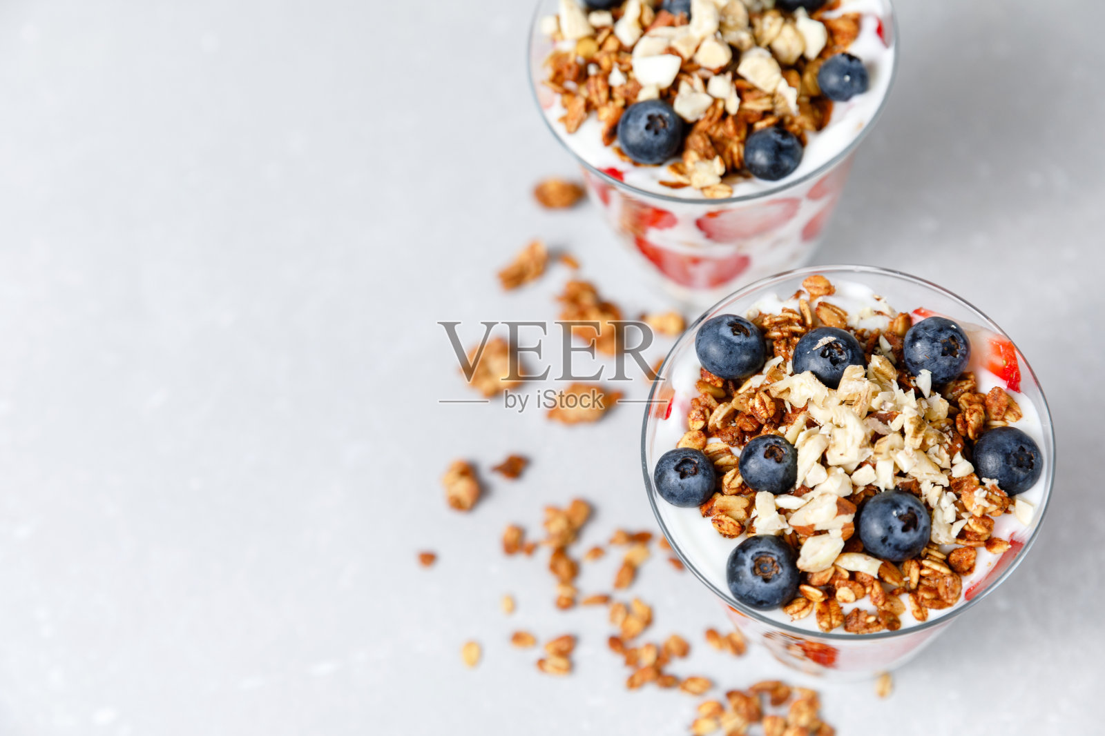 燕麦冻配希腊酸奶，燕麦，新鲜浆果，蜂蜜，高玻璃罐。健康的食物照片摄影图片