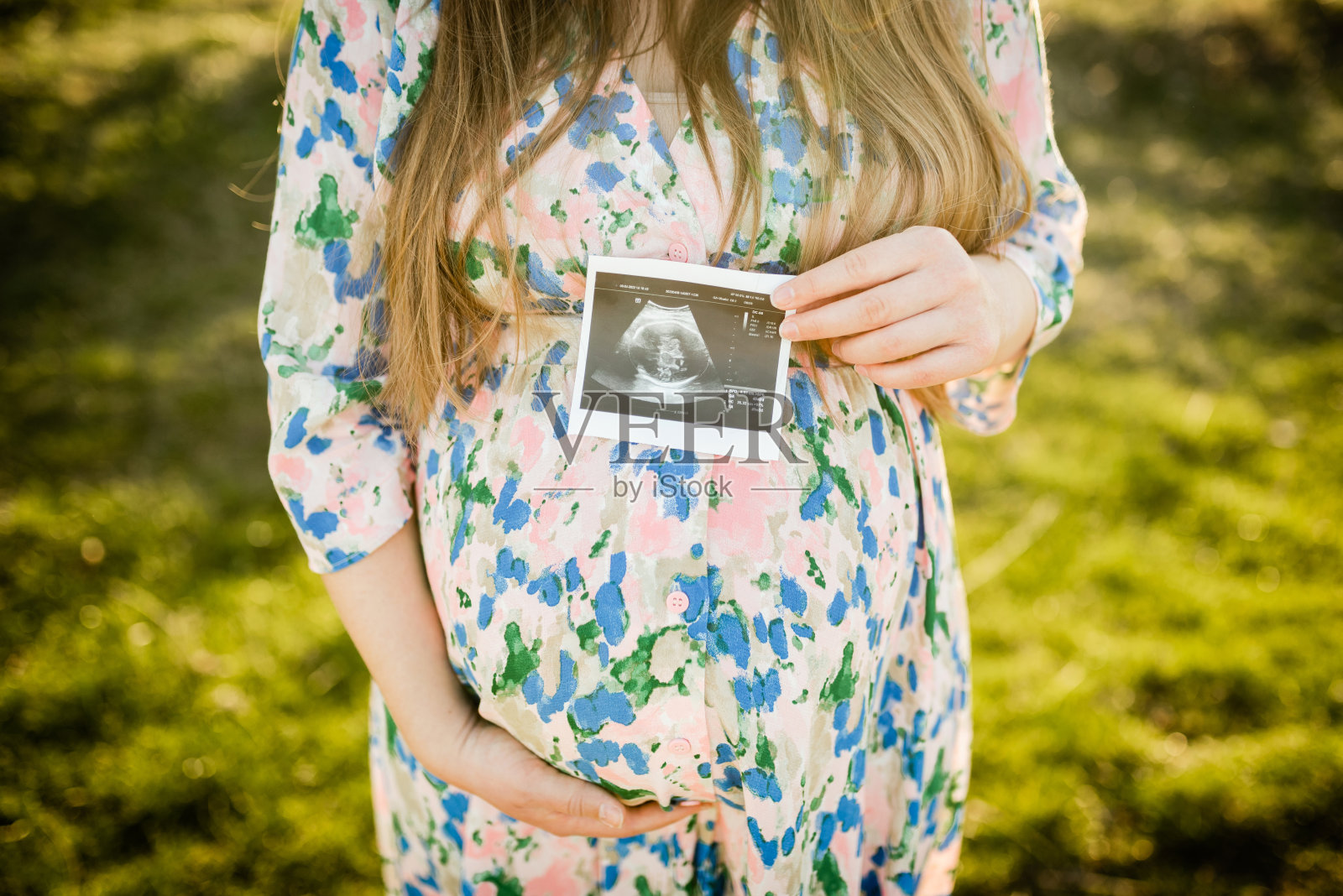 大自然中一名不明身份的孕妇拿着婴儿的照片照片摄影图片