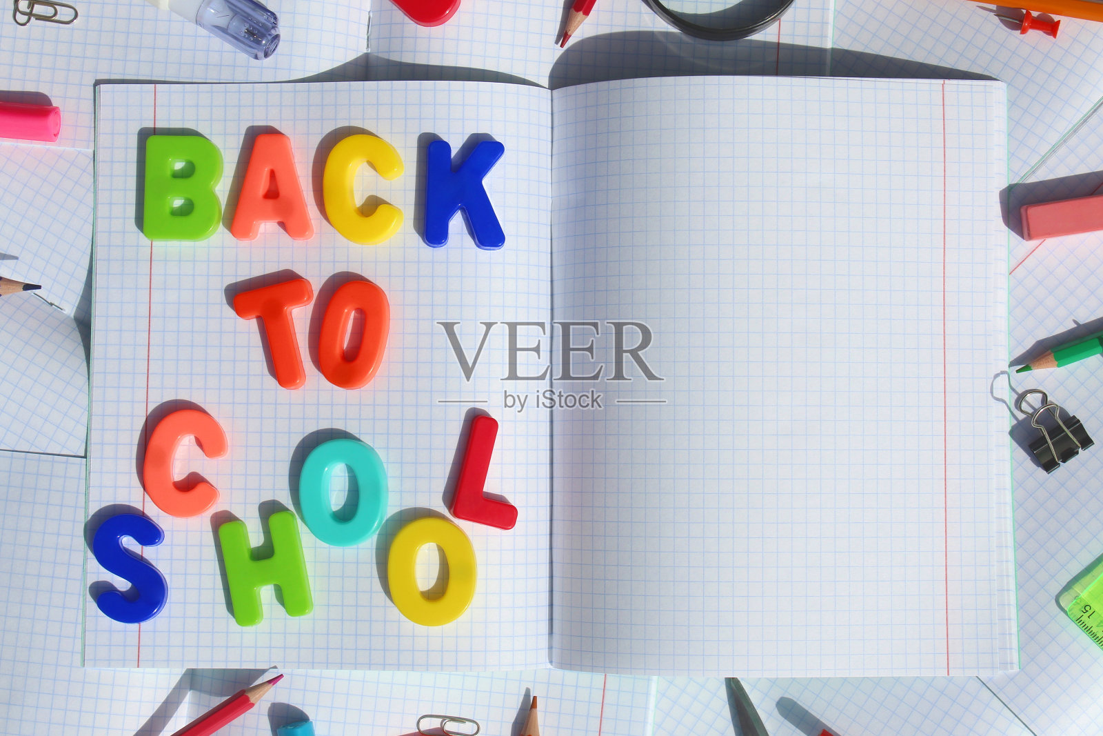 在格子笔记本上写上“马上回学校”照片摄影图片