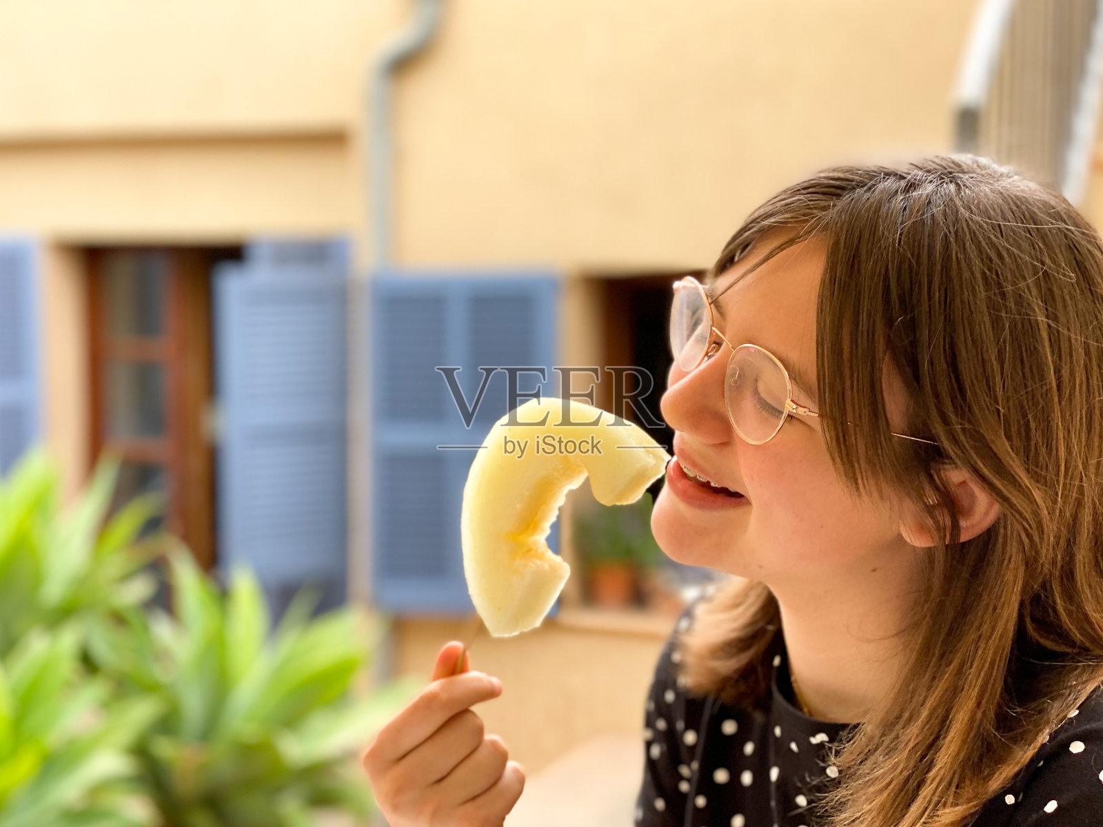 少年以一种有趣的方式吃一片甜瓜照片摄影图片