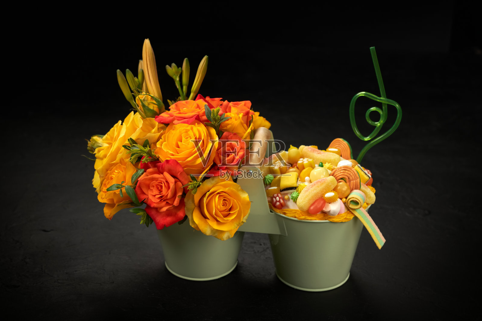 装饰用的金属桶里装满了橘子花和各种形状的糖果照片摄影图片