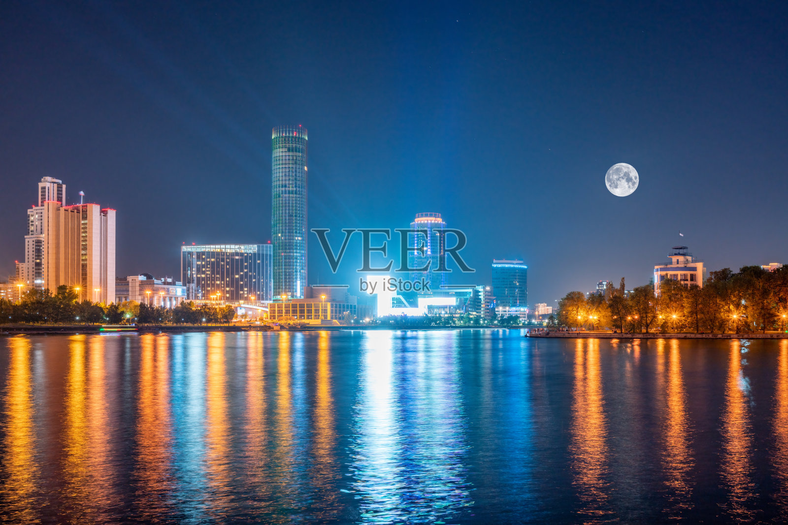 夜晚，城市中心的池塘上有一轮大月亮。夜晚的叶卡捷琳堡和池塘。照片摄影图片