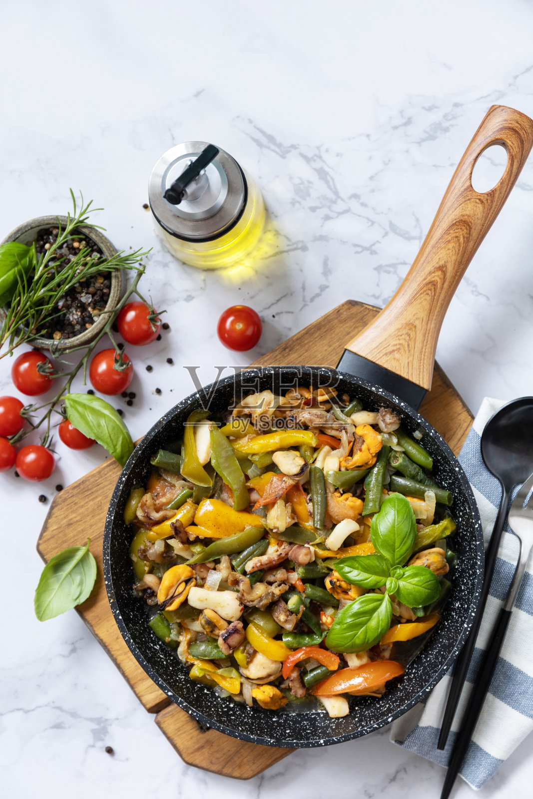 素镬翻炒。大理石桌面上有海鲜虾仁、鱿鱼、墨鱼，配以蔬菜和大蒜酱。俯视图平lay。副本的空间。照片摄影图片