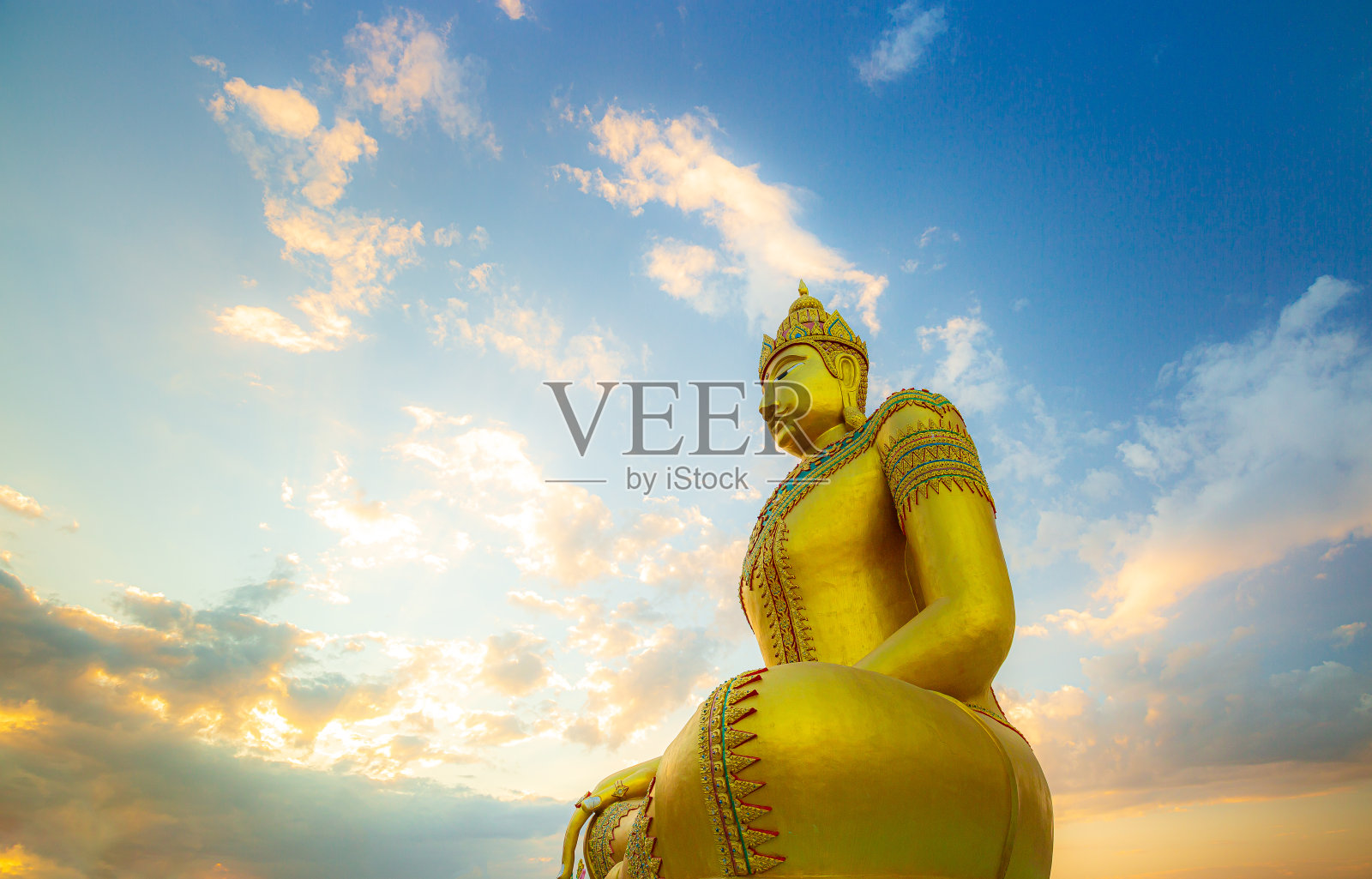 金佛，户外大佛造像，巨大的金佛。以日落或日出为背景的大型佛像。佛像坐着。相信,文化,传统。佛教相信概念照片摄影图片