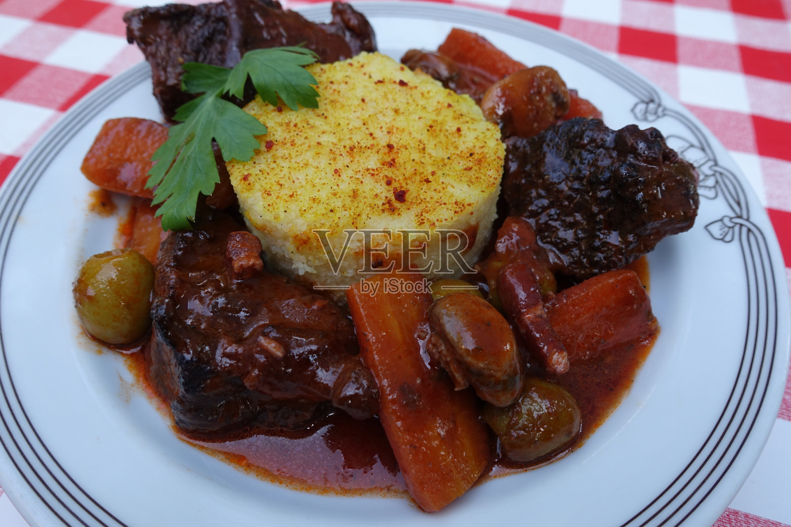 Daube à la provençale用勃艮第红酒酱汁烹制的牛肉，配上胡萝卜、橄榄和蘑菇，配上玉米粥，法国美食照片摄影图片
