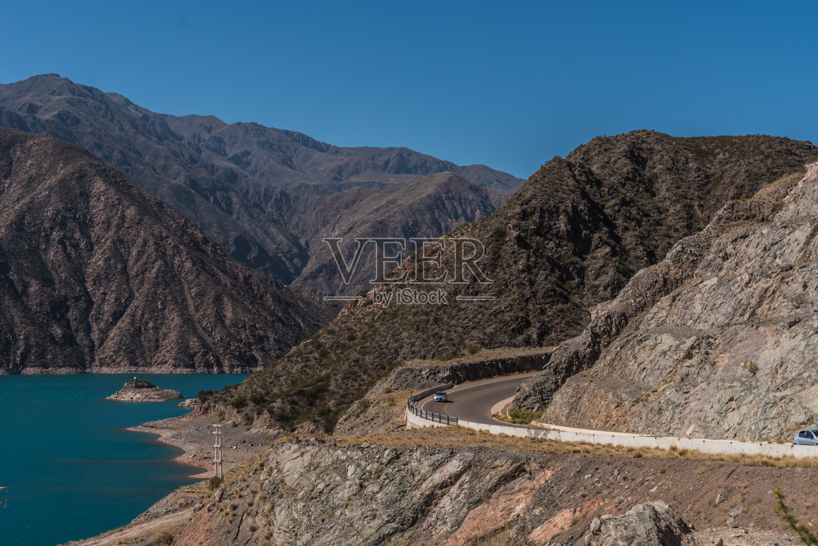 在一个美丽阳光明媚的日子里，阿根廷门多萨，群山之间，绿松石水的大坝照片摄影图片