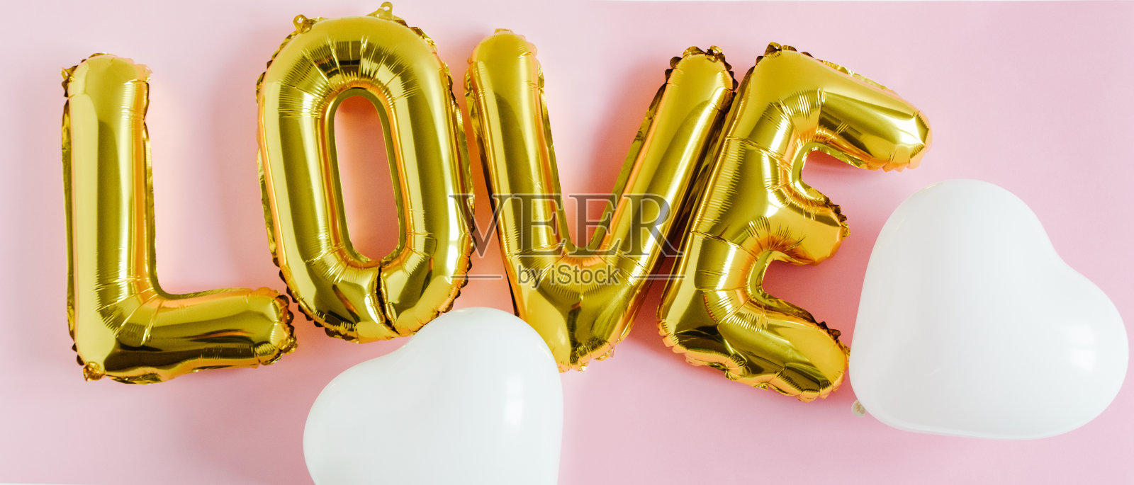 题字爱情箔充气金色气球在粉红色的背景与白色的心。爱情、浪漫和情人节的概念。平躺照片摄影图片