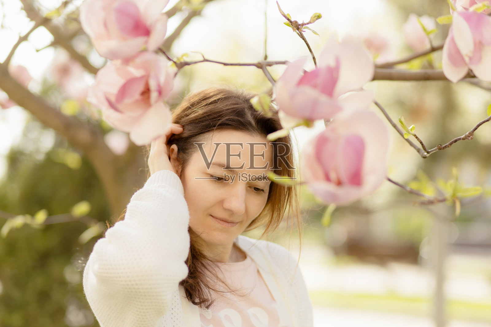 年轻女子和玉兰花。照片摄影图片