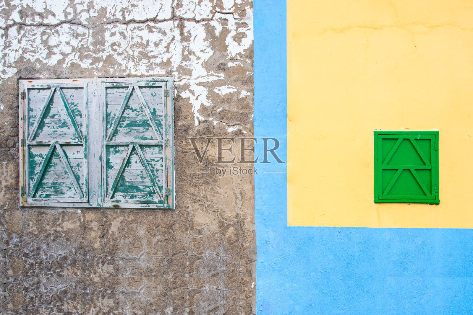 抽象的建筑细节背景。灰色石墙上的老绿窗，黄色建筑上的绿窗。新旧改革观念。照片摄影图片