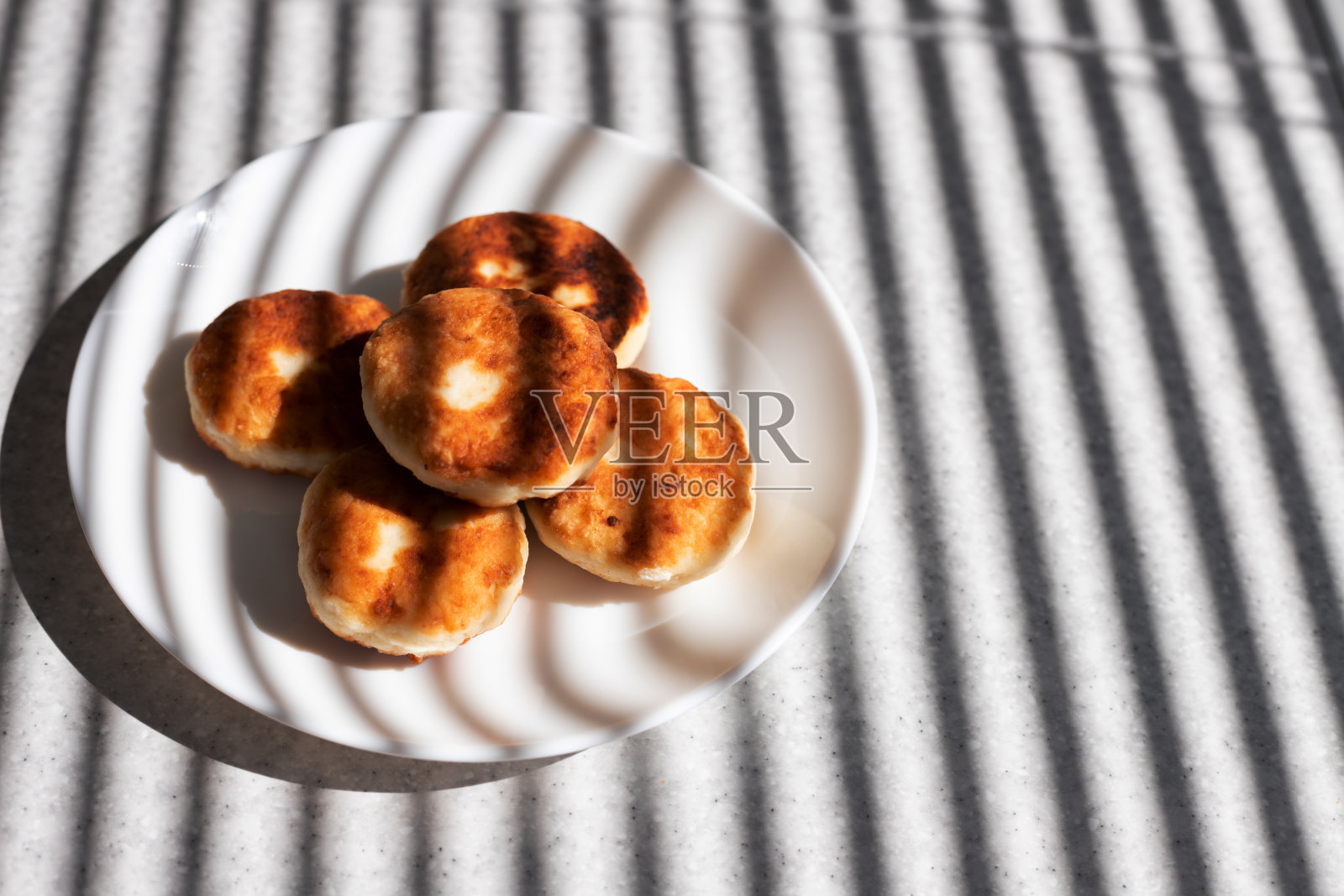 芝士蛋糕放在阳光下桌子上的白色盘子里照片摄影图片