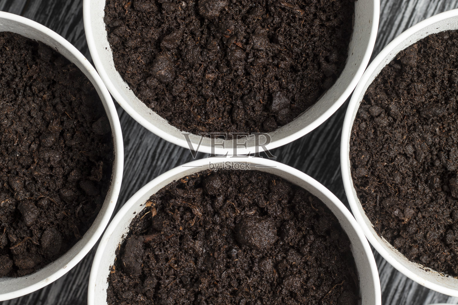 在金属罐中用泥炭制成的盆栽土壤。照片摄影图片