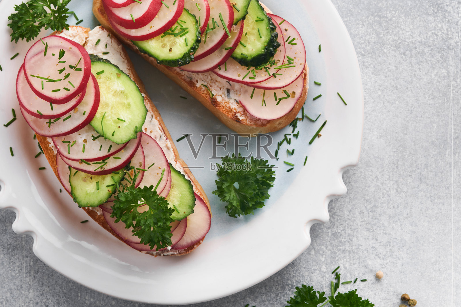 加奶酪和萝卜的吐司。灰色混凝土背景下的三明治配上白干酪、萝卜、黄瓜和青葱。健康的三明治。传统的北欧吐司。前视图。照片摄影图片
