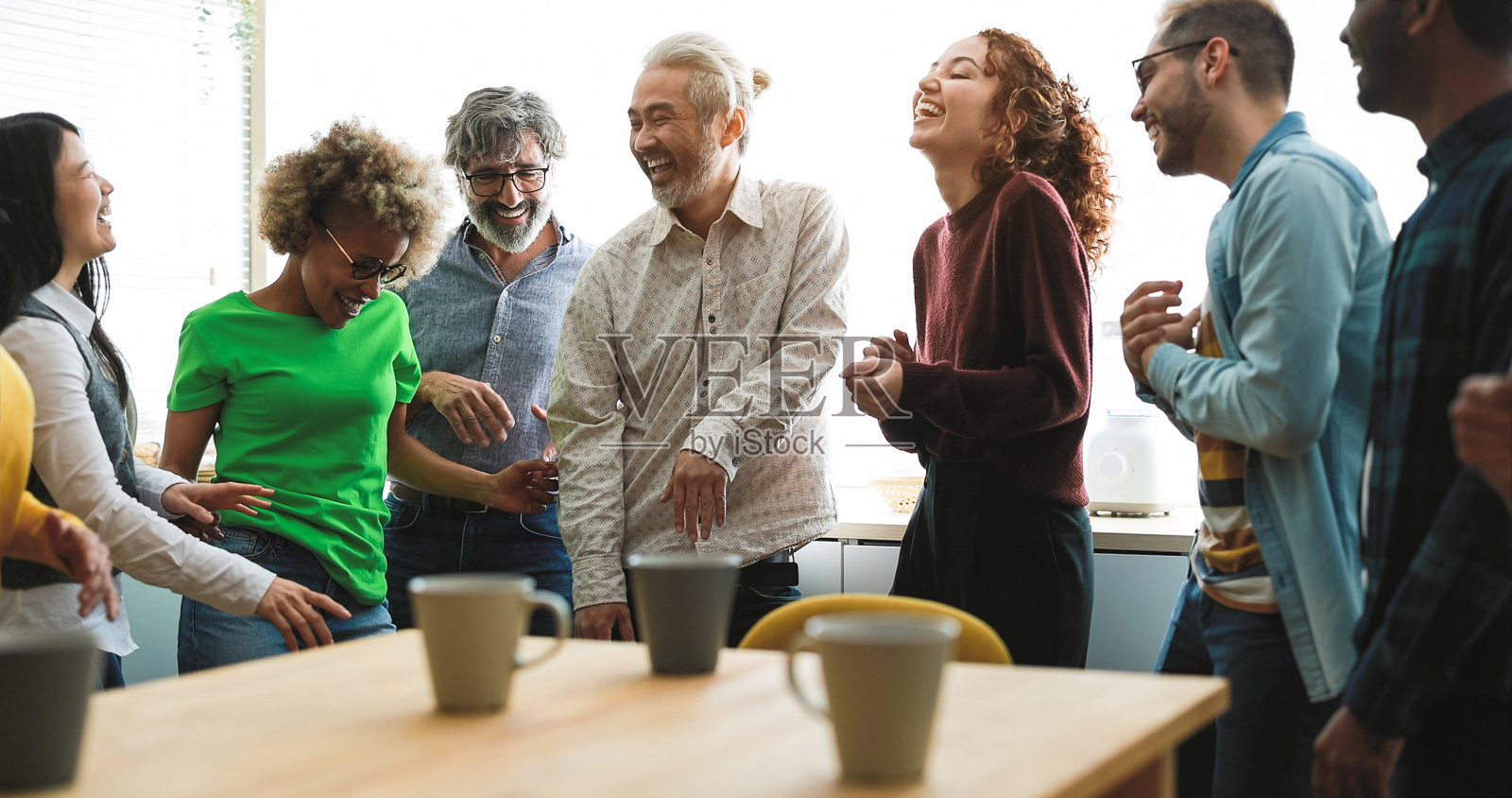 多代朋友有乐趣在家里厨房跳舞-专注于左高级男子的脸照片摄影图片