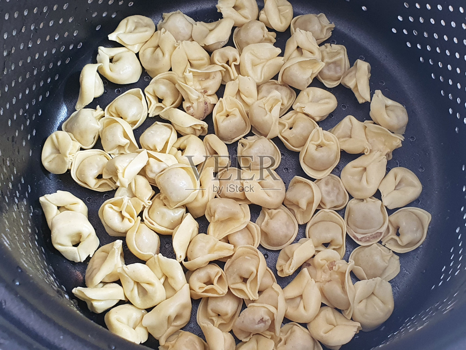 在锅里放上卡布雷蒂，再往开水里开照片摄影图片