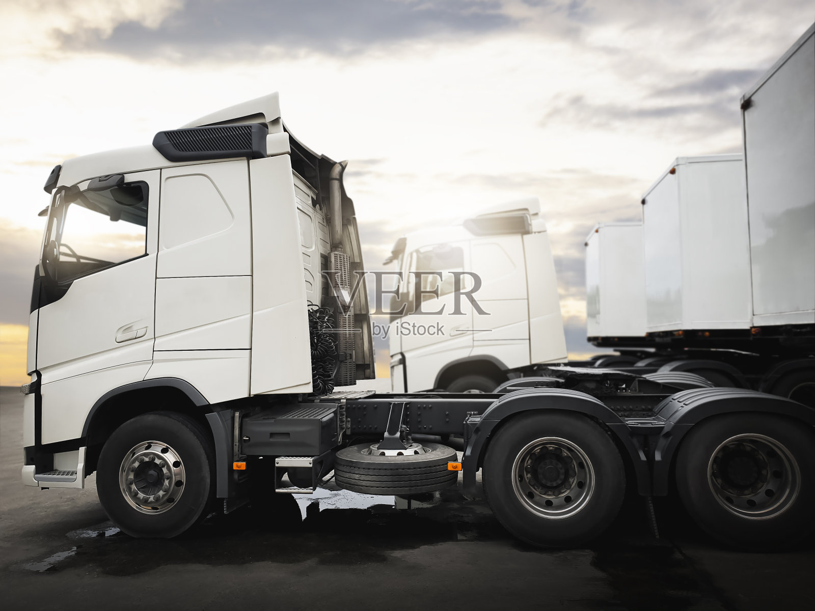 与日落天空一起停放的半挂车。集装箱卡车。引擎柴油卡车。卡车拖拉机。工业、货运、卡车、物流、货物运输。照片摄影图片