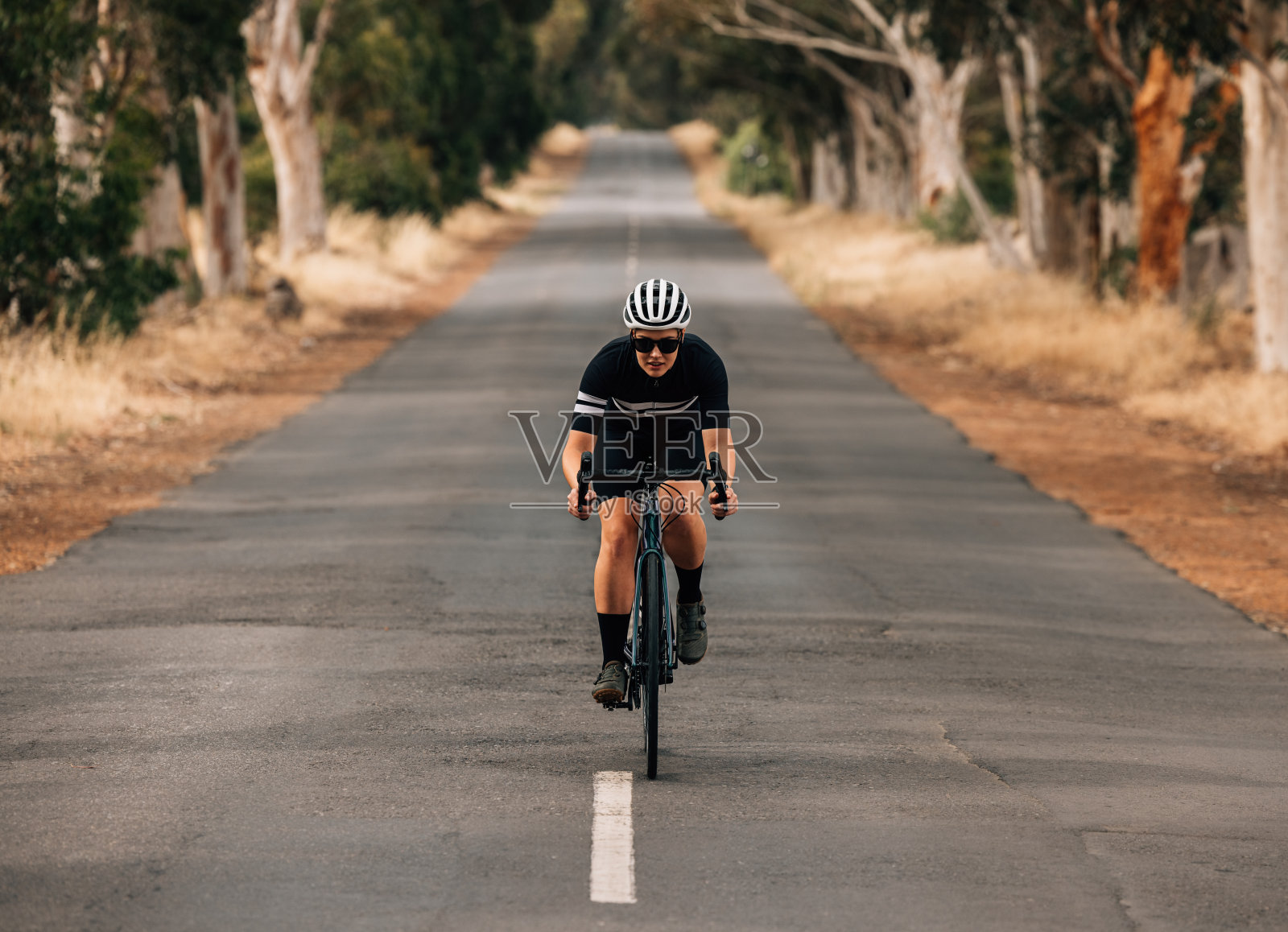 运动员在空旷的乡村公路上骑自行车。专业户外自行车训练。照片摄影图片