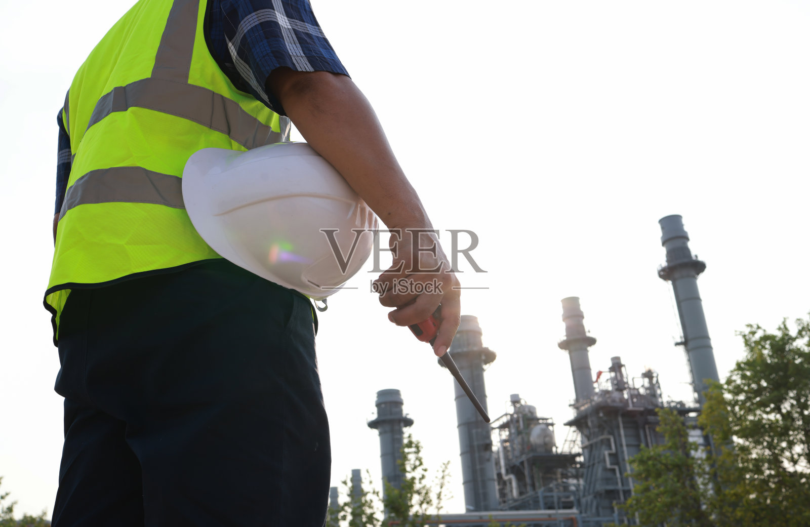 近距离拍摄男工程师穿着安全背心、安全帽和对讲机在户外工作，现场一线工程师的工作理念照片摄影图片