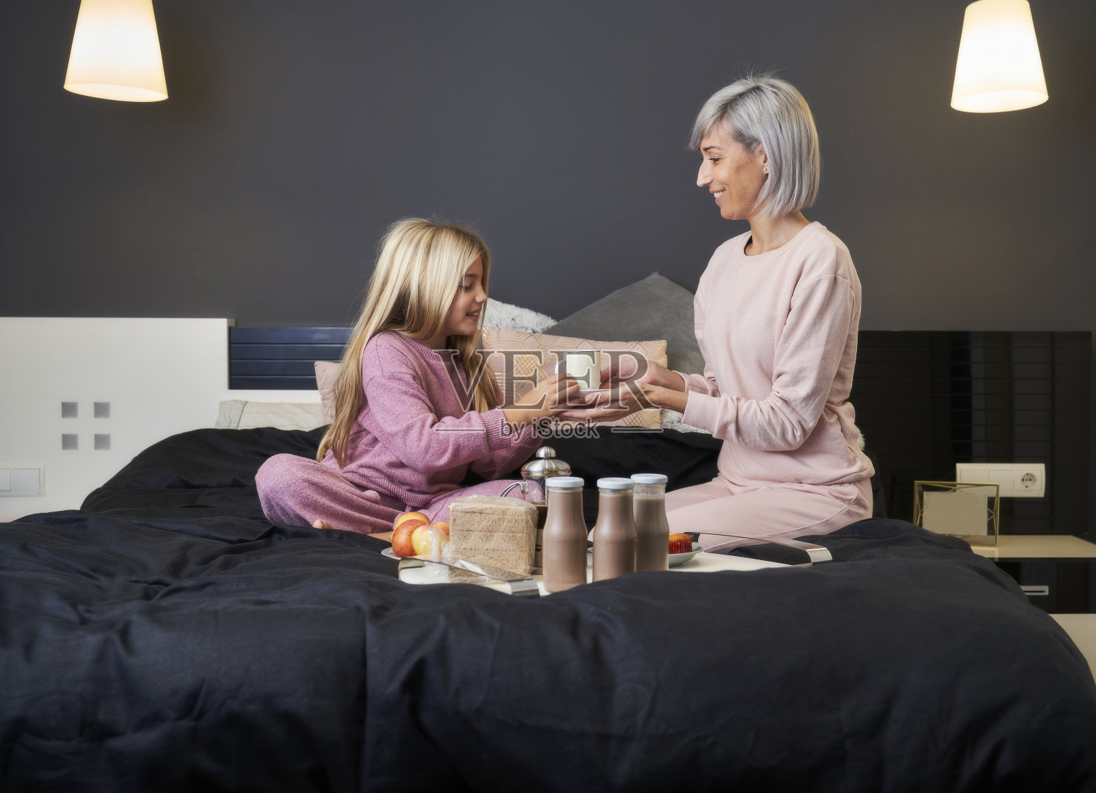 母女俩在床上吃早餐照片摄影图片