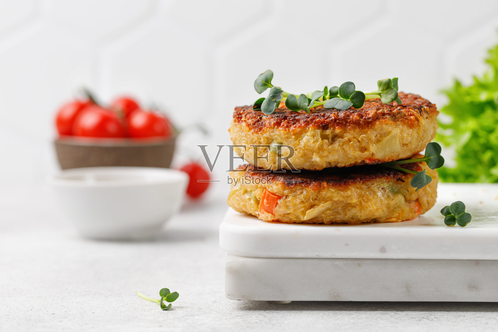 素食汉堡，藜麦肉片和蔬菜放在大理石板上。健康食品的概念。照片摄影图片