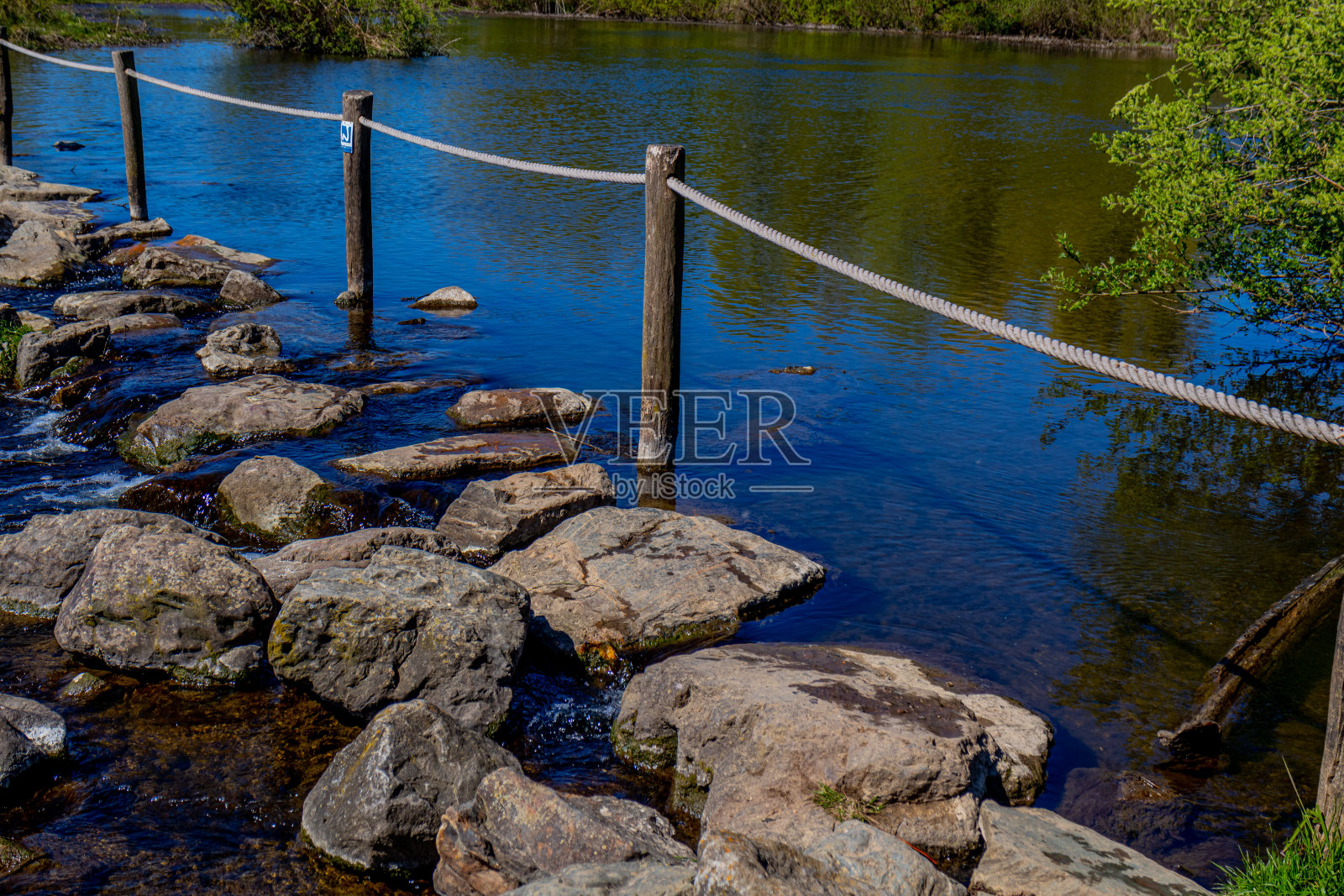 木桩和绳子栅栏，在布鲁格莫伦普拉斯的踏脚石越过欧德马斯河，平静的水面照片摄影图片