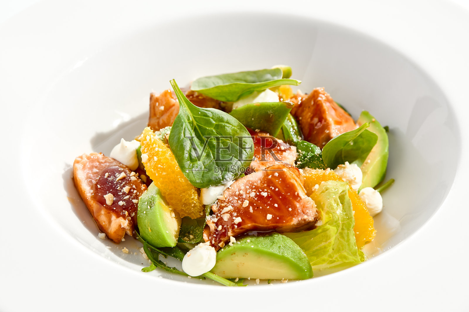 健康午餐——金枪鱼、鳄梨和橙汁的绿色沙拉。金枪鱼沙拉。餐厅菜单上的清洁饮食。以菠菜，鳄梨，柑橘为原料的烤鱼。酮饮食。照片摄影图片