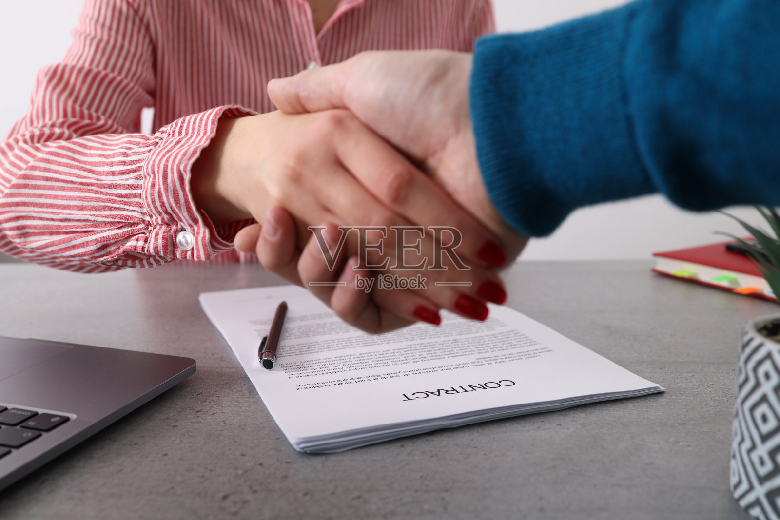 商人和女商人正在握手签合同。照片摄影图片