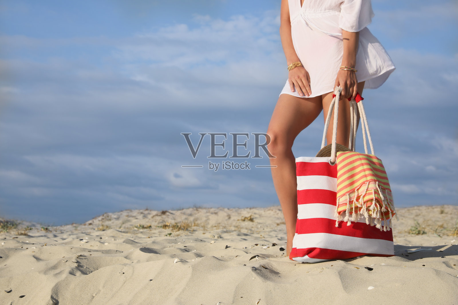 拿着沙滩包的女人，特写照片摄影图片