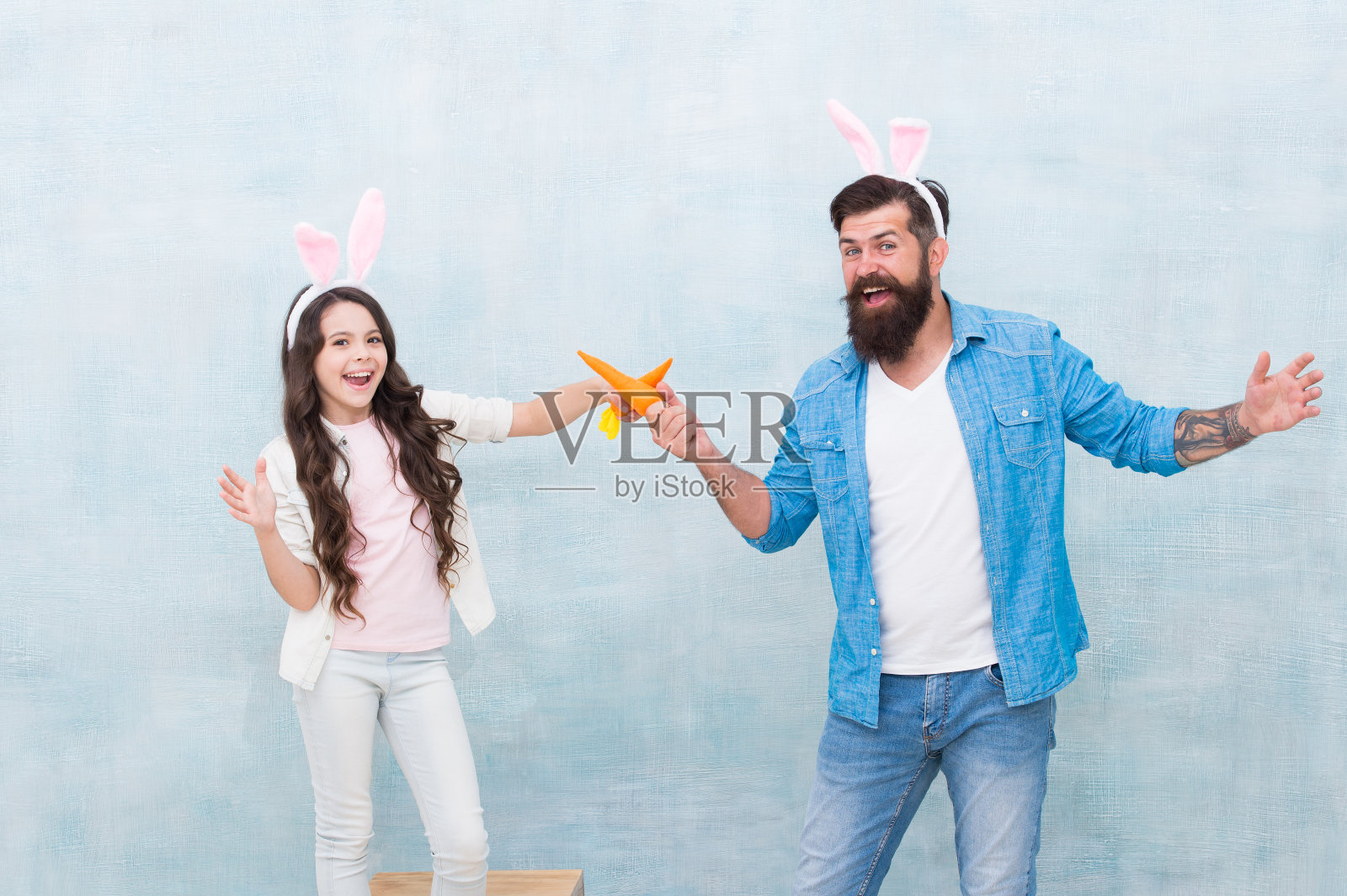 烹饪复活节食物：戴兔子耳朵的女孩和爸爸照片摄影图片