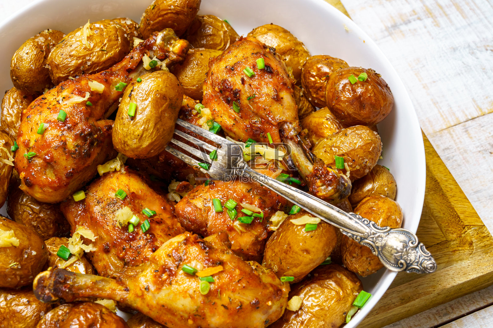 美味的乡村风味午餐，健康的食物——炸鸡和不去皮的烤土豆，切碎的韭菜，熟食为背景照片摄影图片