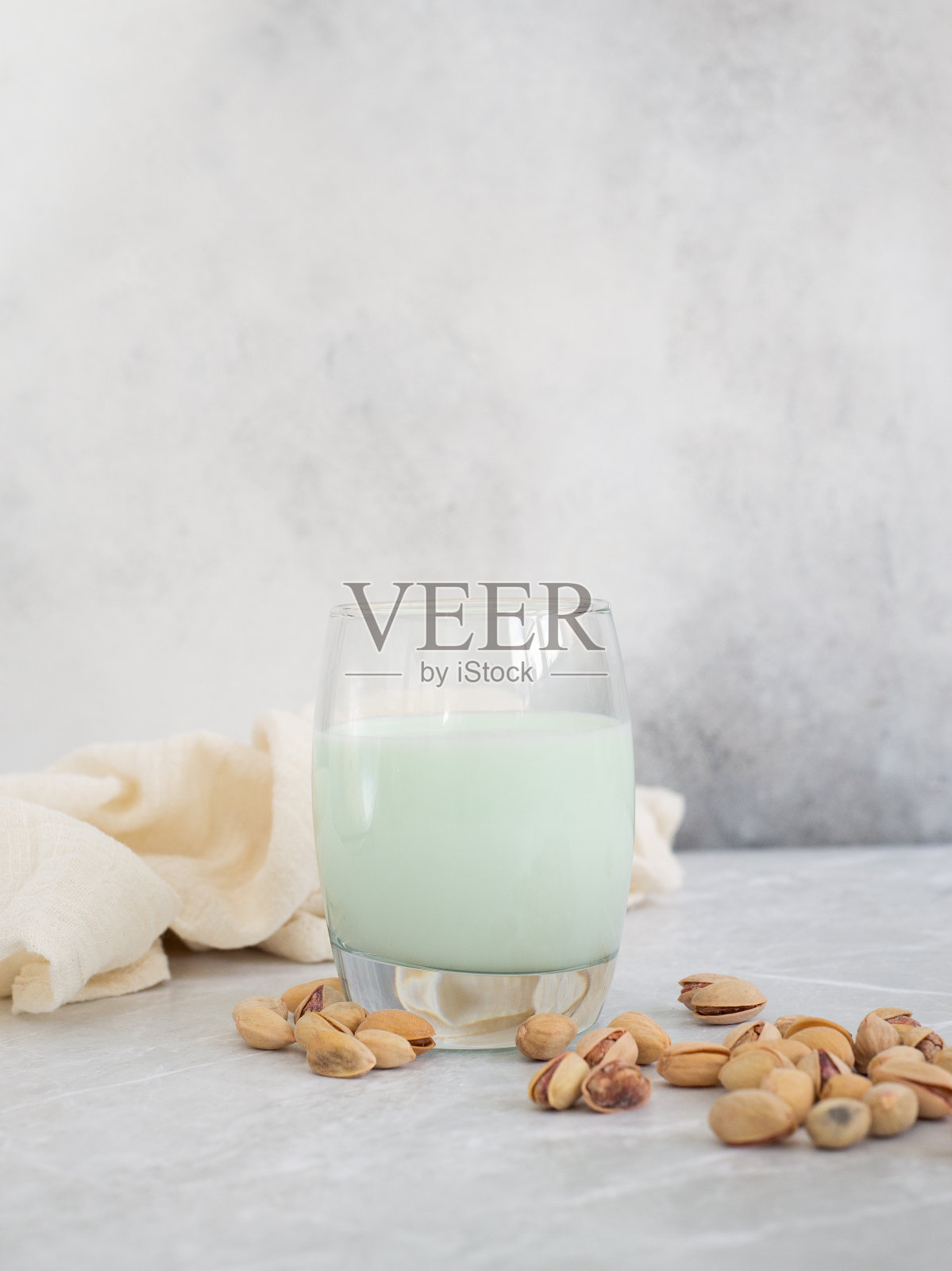 开心果牛奶，在灰色的背景上有开心果。照片摄影图片