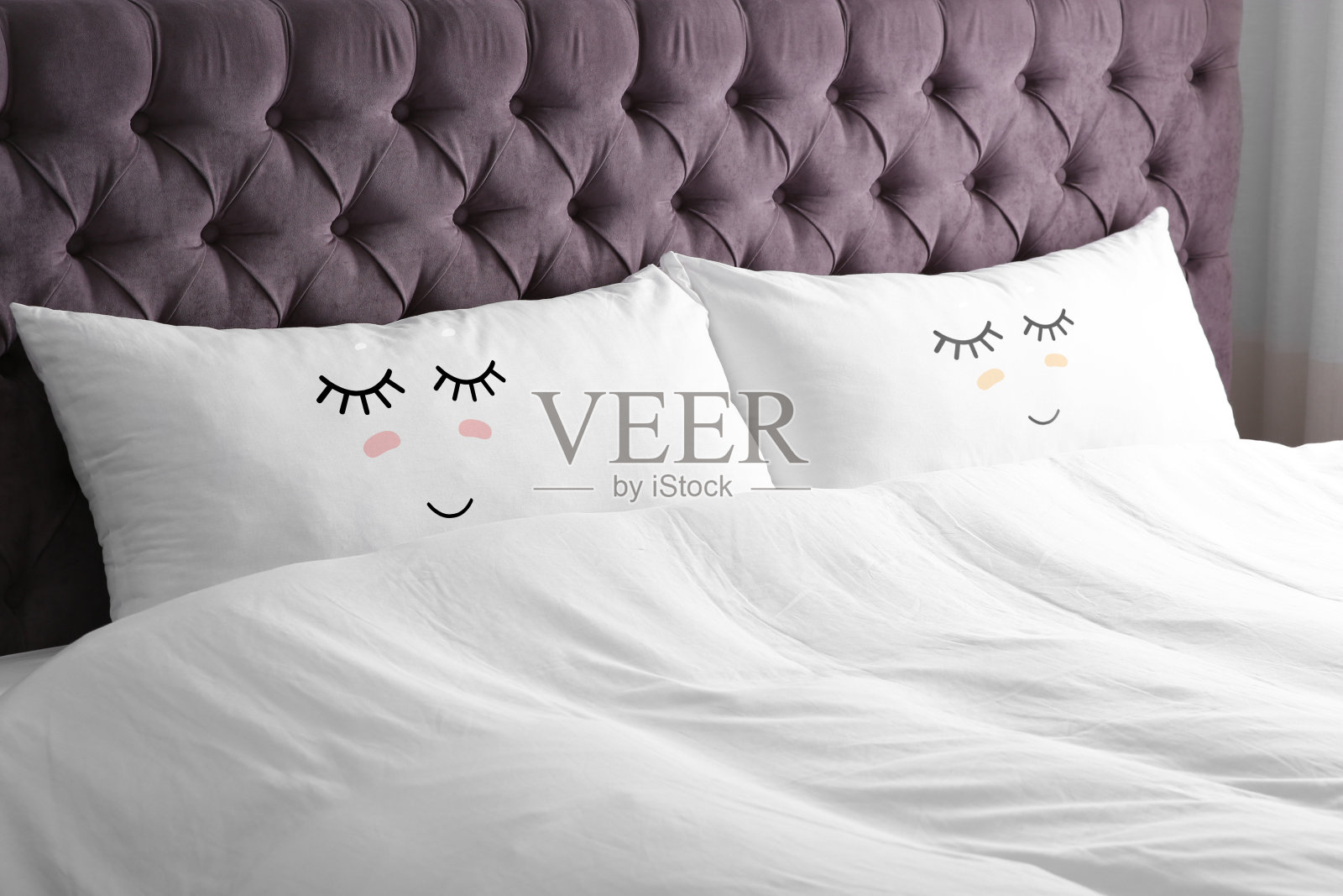 柔软的枕头和可爱的脸在舒适的床上照片摄影图片