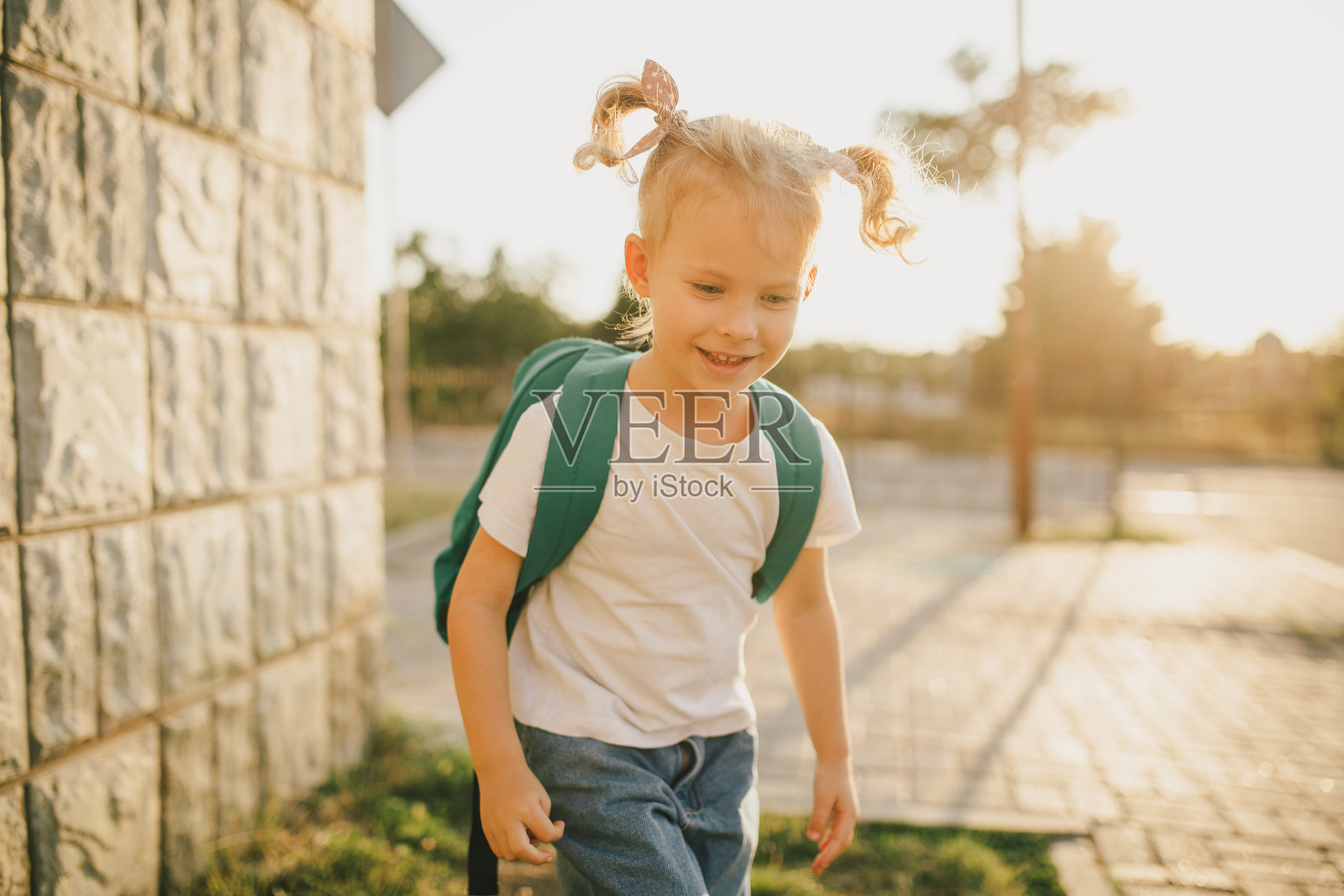 可爱的小女生背着书包在街上照片摄影图片