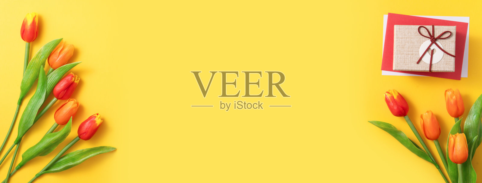 母亲节的背景。顶视图的礼物与郁金香花束在黄色的桌子背景照片摄影图片