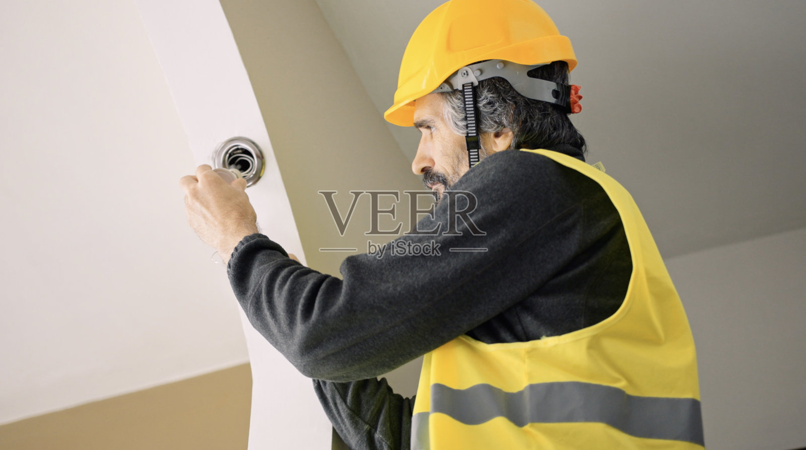 安装房屋电气的工程师。碳中和和节能。照片摄影图片