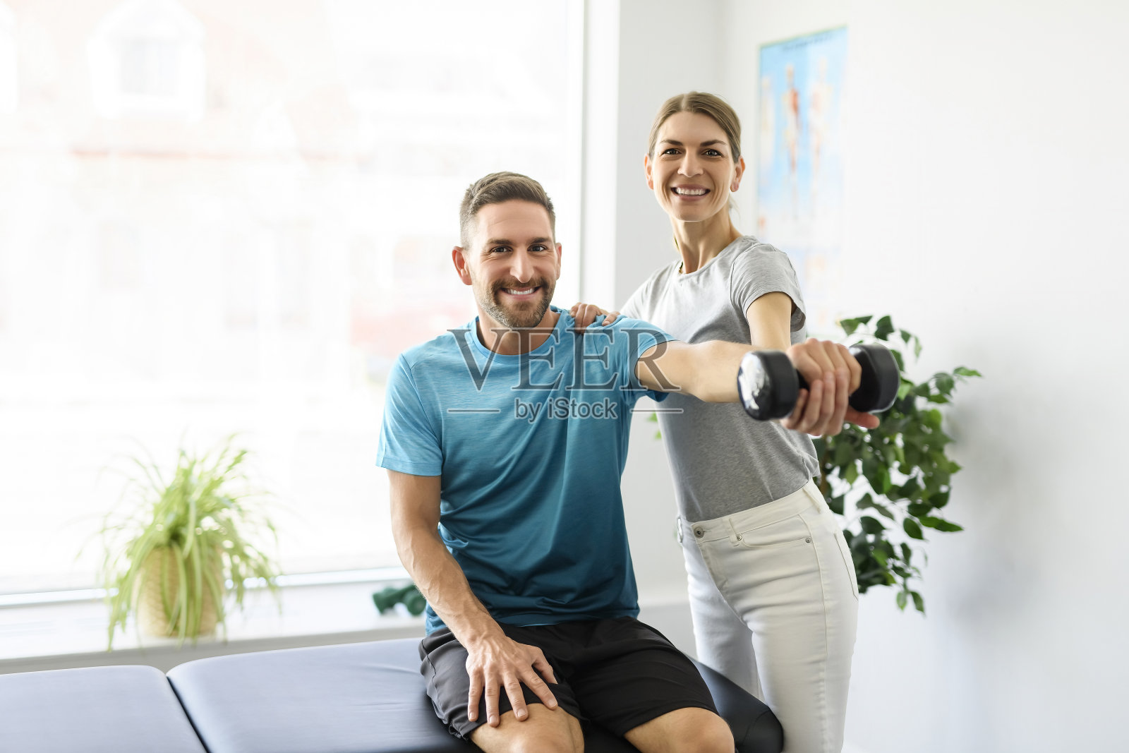 现代康复理疗女性工作者与男性客户照片摄影图片