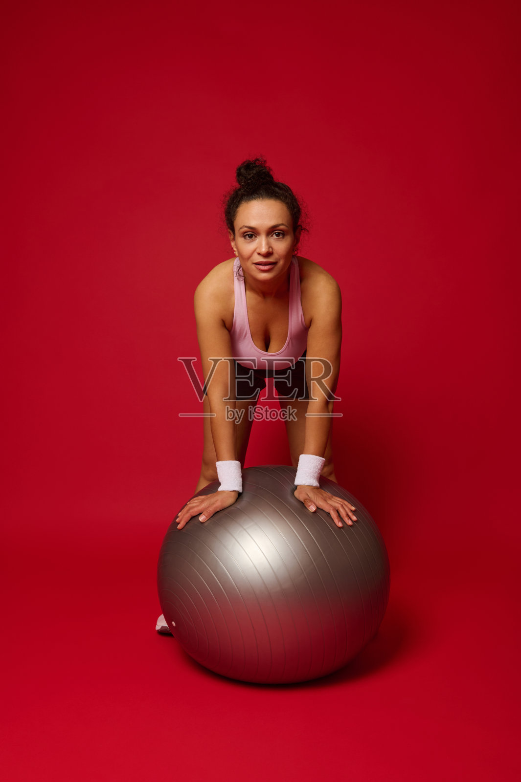 一个美丽的运动员女人的肖像与一个适合的球孤立在红色的背景与拷贝广告空间照片摄影图片