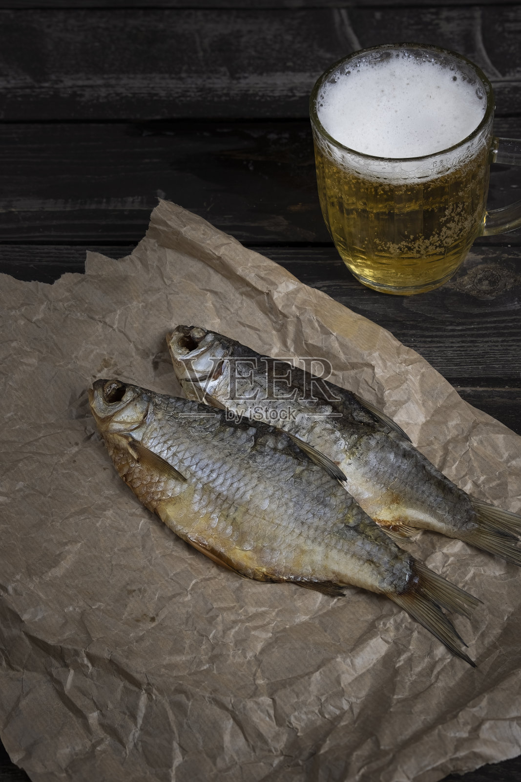 咸鱼干，琥珀色啤酒，黑木底，面包照片摄影图片